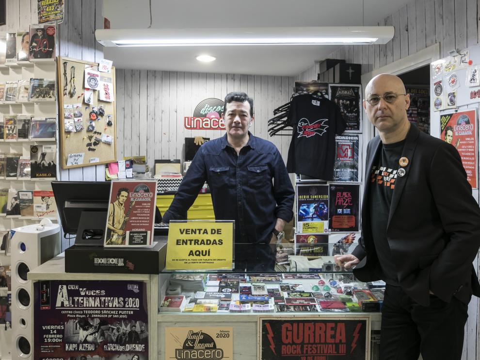 Luis Linacero (izquierda) y Chema Fernández, en Discos Linacero, apoyados en un expositor lleno de tacos de entradas.