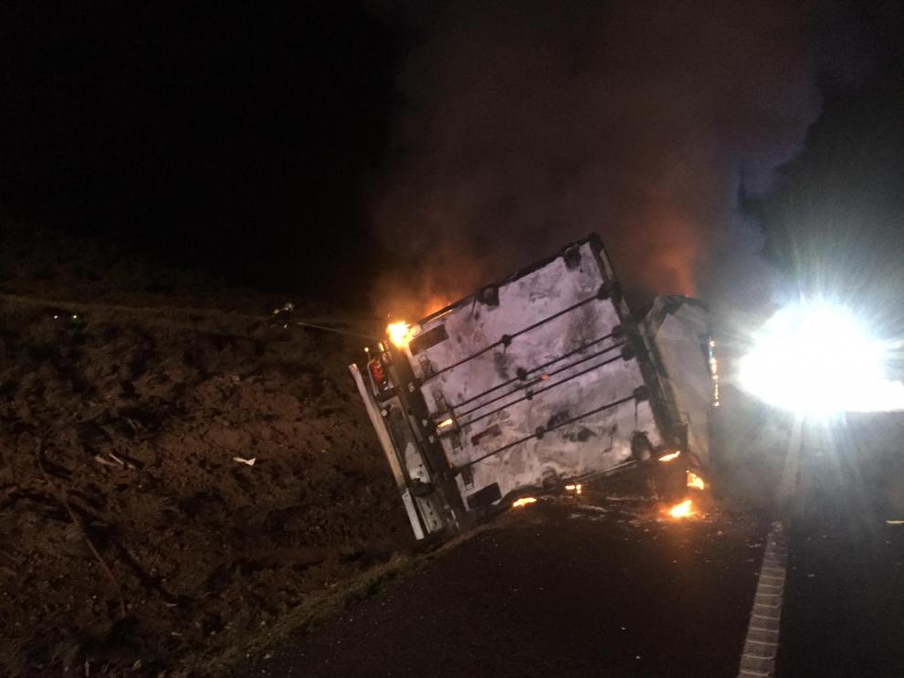 El camión ha volcado entre la cuneta y la calzada y ha comenzado a arder.