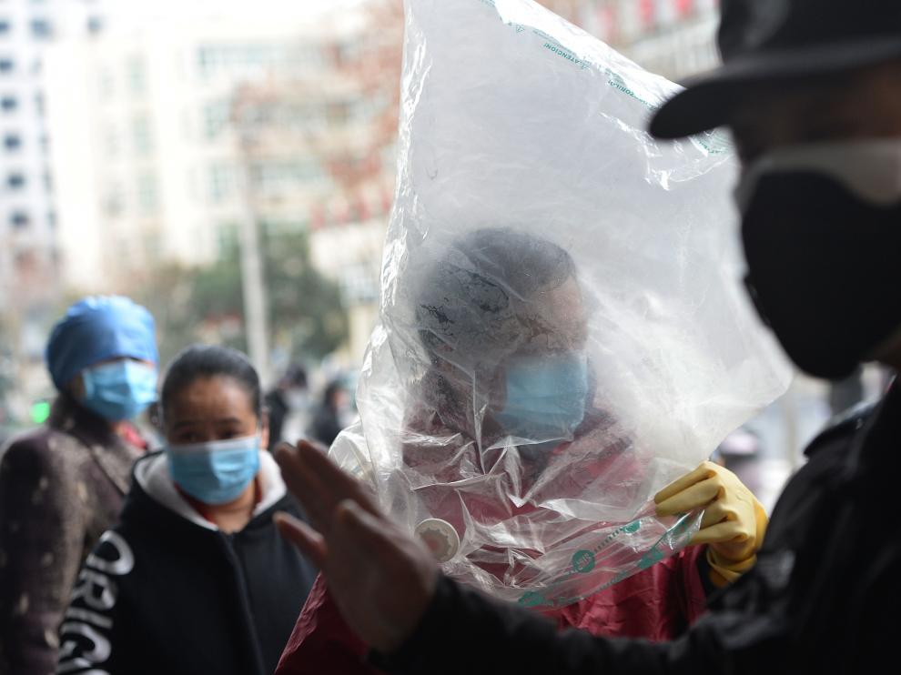 Un ciudadano chino protegido con una bolsa de plástico sobre la cabeza