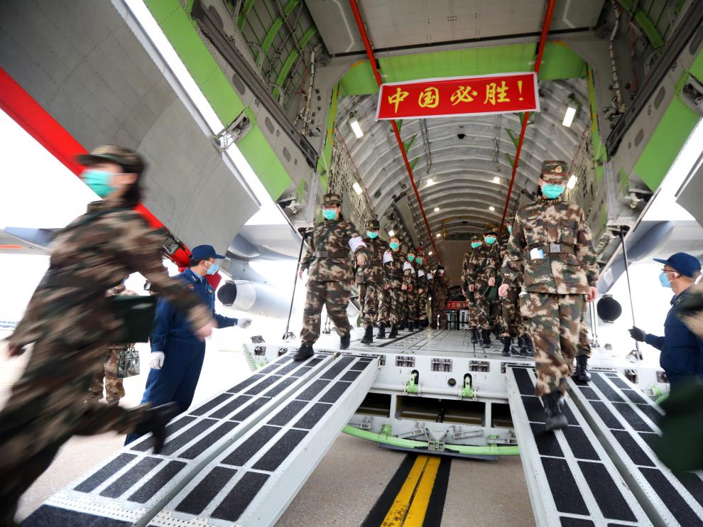 El personal médico llega con suministros médicos en un avión de transporte de la Fuerza Aérea del Ejército Popular de Liberación de China al aeropuerto Internacional de Wuhan
