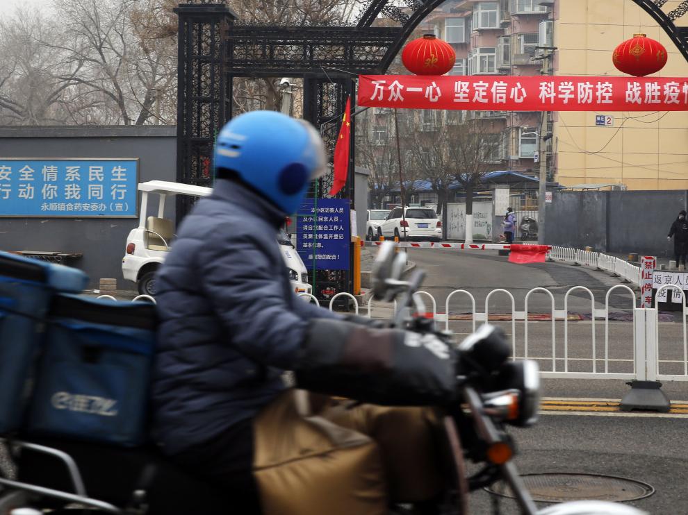 Beijing (China), 13/02/2020.- A food delivery man riding bicycle pass a banner reading 'Unite as one, firm confidence, scientific prevention and control, and defeat the epidemic' in Beijing, China, 13 February 2020. The disease caused by the novel coronavirus (SARS-CoV-2) has been officially named Covid-19 by the World Health Organization (WHO). The outbreak, which originated in the Chinese city of Wuhan, has so far killed at least 1,369 people with over 60,000 infected worldwide, mostly in China. EFE/EPA/WU HONG Propaganda banners about coronavirus in Beijing