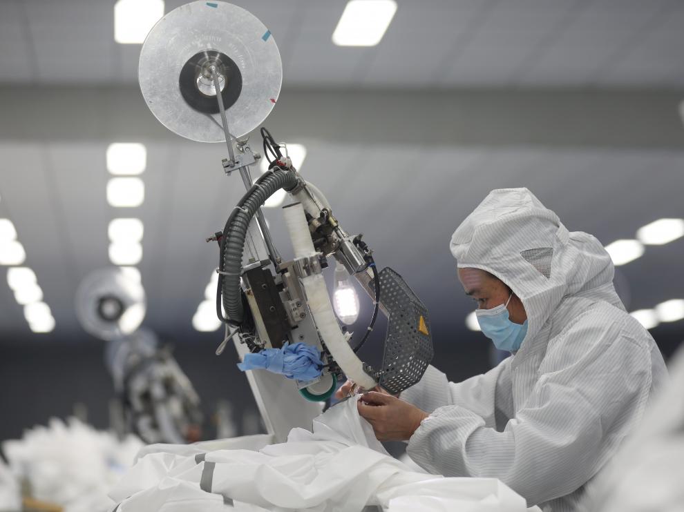 Un empleado trabaja en una línea de producción de trajes protectores en Wuhan.