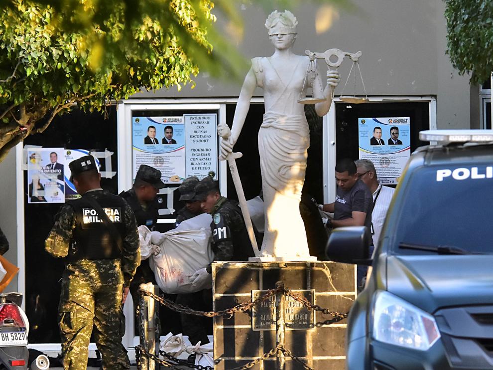 Un grupo de policías lleva el cuerpo sin vida de uno de los agentes asesinados en el juzgado de la ciudad de El Progreso