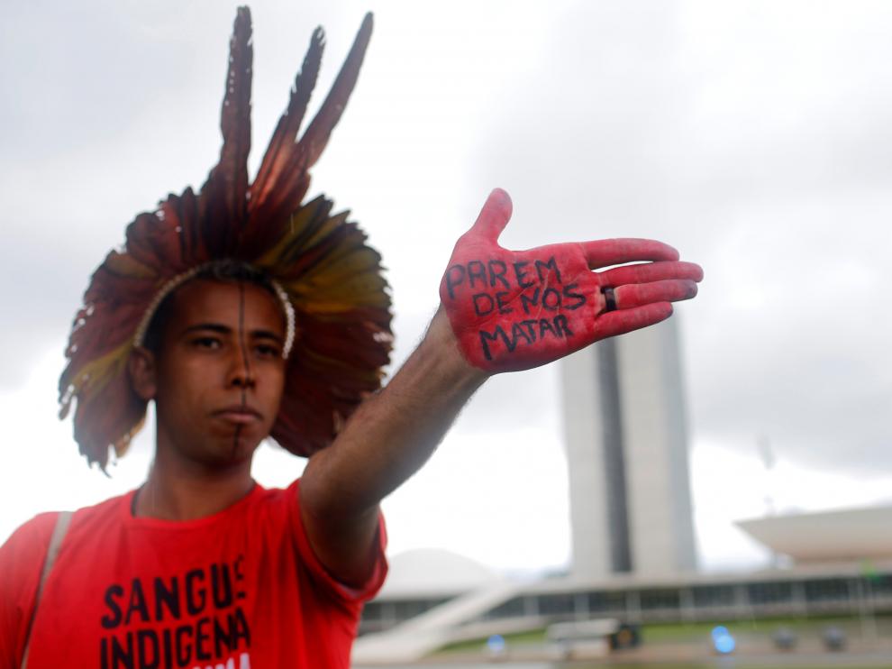 Un hombre indígena muestra su mano con el lema "dejen de matarnos", durante una protesta contra el gobierno de Bolsonaro