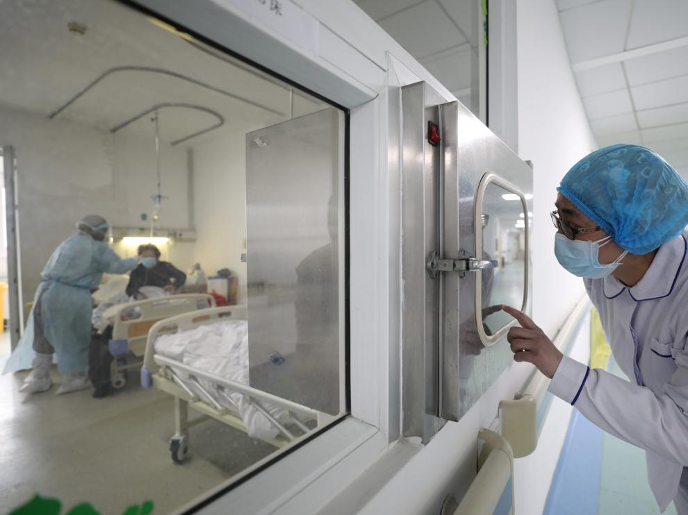 Persona sanitario atiende a un paciente aislado por el coronavirus en un hospital de Wuhan, el epicentro de la epidemia.