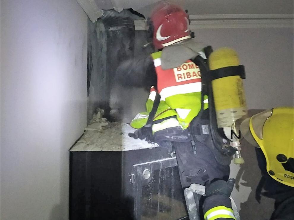 Dos bomberos comprueban la situación de la chimenea incendiada.