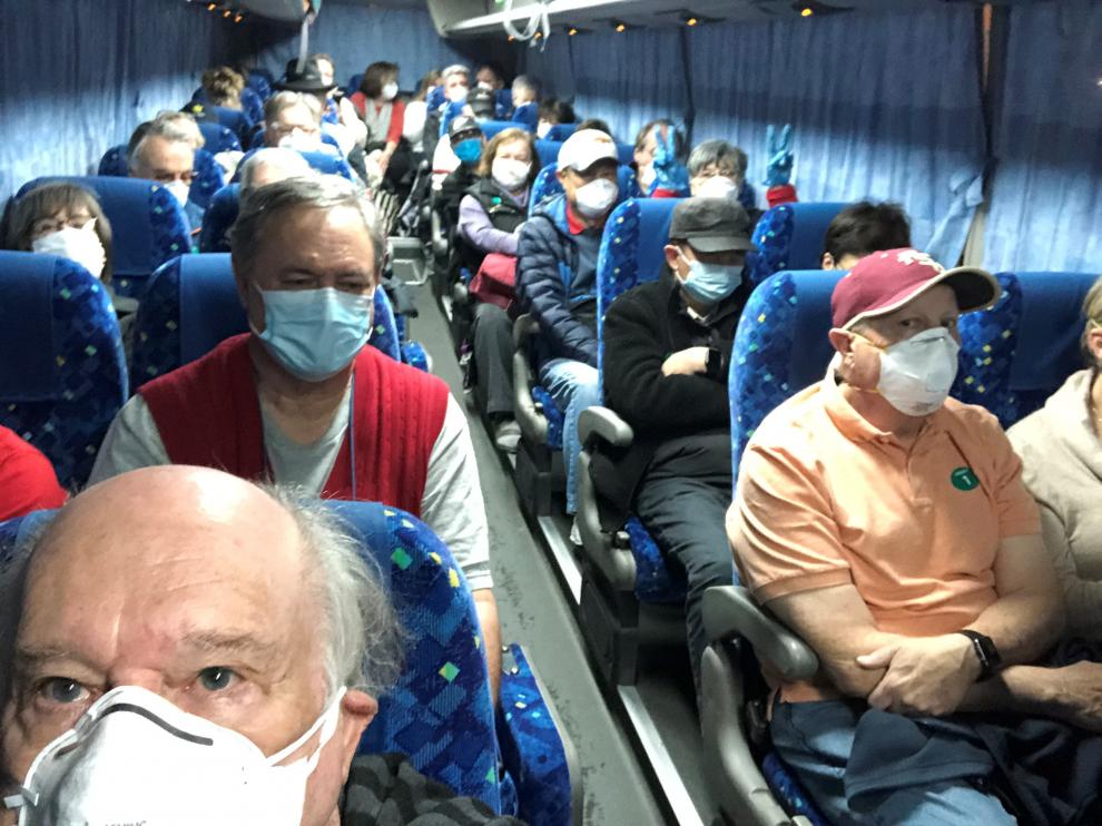 Pasajeros estadounidenses del crucero Diamond Princess que han elegido marcharse son trasladados en un bus al aeropuerto de Haneda para volvar a Estados Unidos.