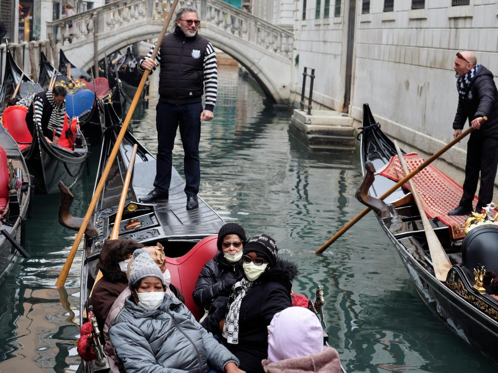 Tourists wear protective face masks at Venice Carnival, which the last two days of, as well as Sunday night's festivities, have been cancelled because of an outbreak of coronavirus, in Venice, Italy February 23, 2020. REUTERS/Manuel Silvestri [[[REUTERS VOCENTO]]] CHINA-HEALTH/ITALY-VENICE