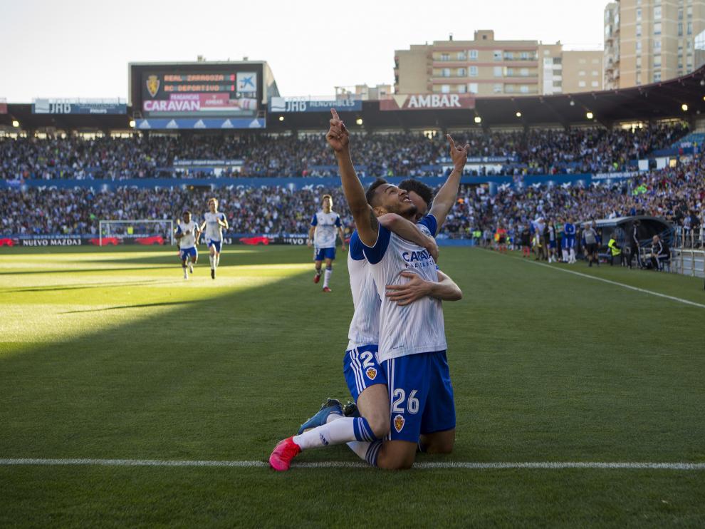 Luis Suárez, de rodillas, mira al cielo mientras es abrazado por Burgui.