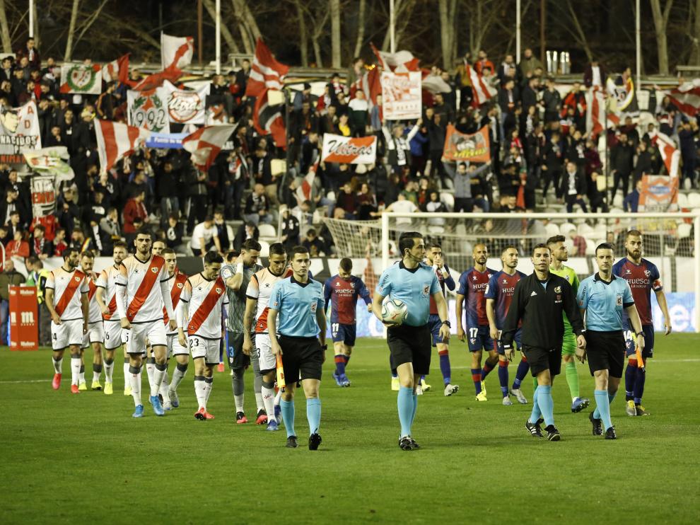 El árbitro Saúl Ais Reig, encabezando la salida del Rayo y la SD Huesca al campo.
