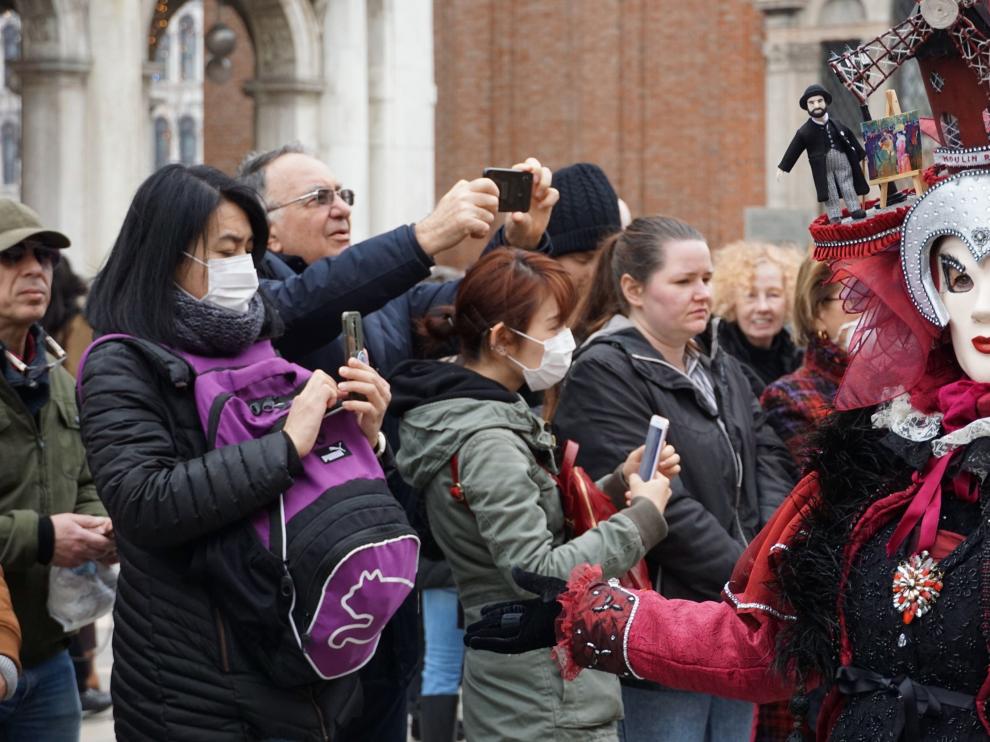 Turistas con máscaras protectoras visitando este lunes la plaza de San Marcos, en Venecia.