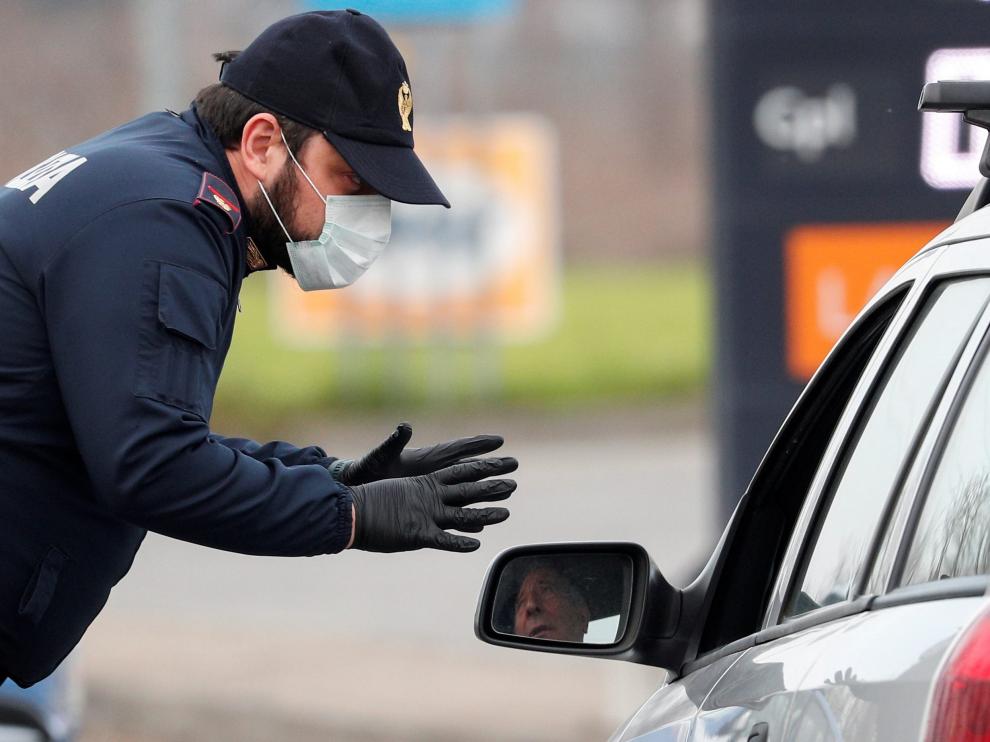 Un policía de Codogno con mascarilla advierte a un conductor que circula por la carretera entre este municipio y Casalpusterlengo.