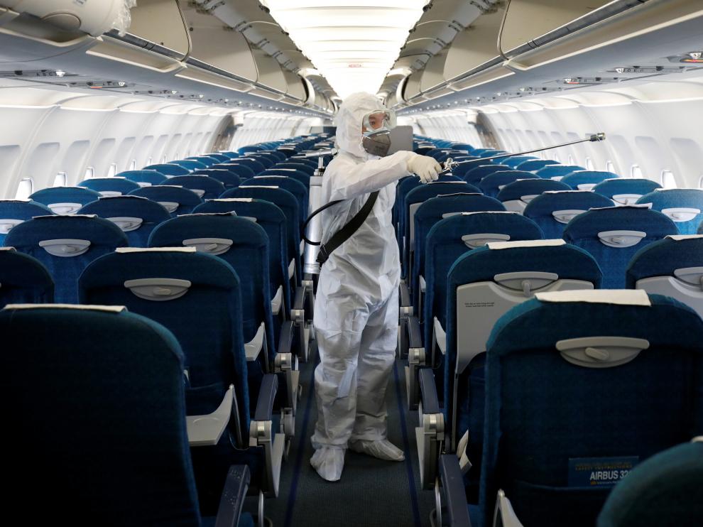 FILE PHOTO: A health worker sprays disinfectant inside a Vietnam Airlines airplane to protect against the recent coronavirus outbreak, at Noi Bai airport in Hanoi, Vietnam