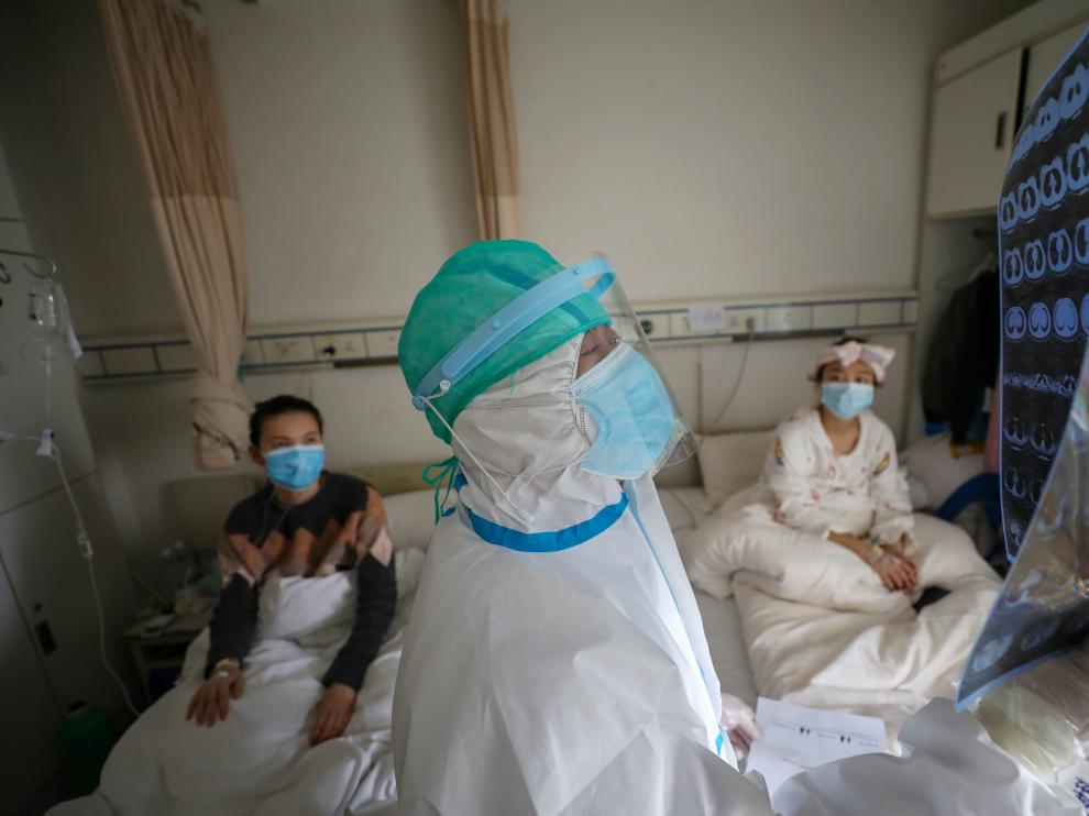 Medical worker in protective suit inspects a CT scan image at a ward of Wuhan Red Cross Hospital in Wuhan