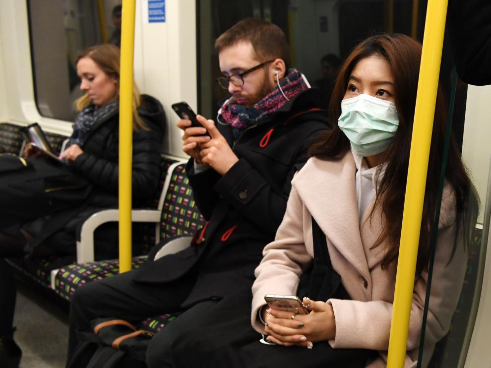 Una mujer con máscara en el metro de Lon