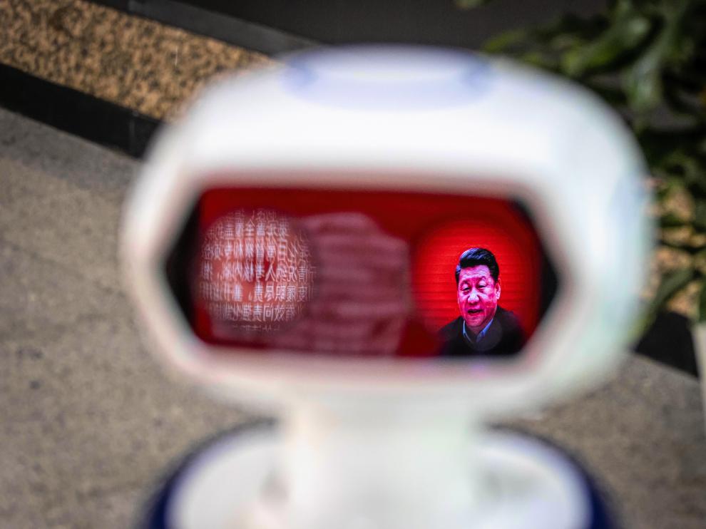 Una imagen del presidente de China Xi Jinping, reflejada en el visor de un robot que detecta la temperatura corporal.