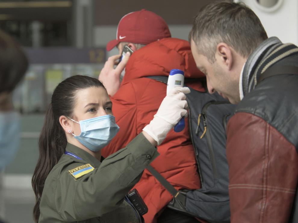 Passengers arriving at airport in Lviv, Ukraine, get their temperatures checked for coronavirus screening