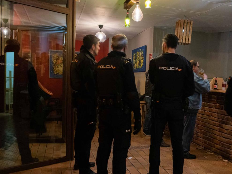 Un cliente del bar Toca Jamón apura la cerveza mientras la Policía Local clausura el local por la crisis del coronavirus.