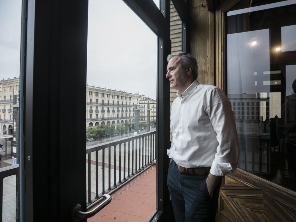 El alcalde de Zaragoza, Jorge Azcón, observa la plaza del Pilar desierta desde su despacho del Ayuntamiento.