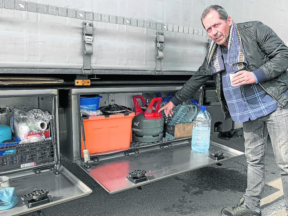 El camionero portugués Víctor Silva muestra su cocina de gas mientras toma un café