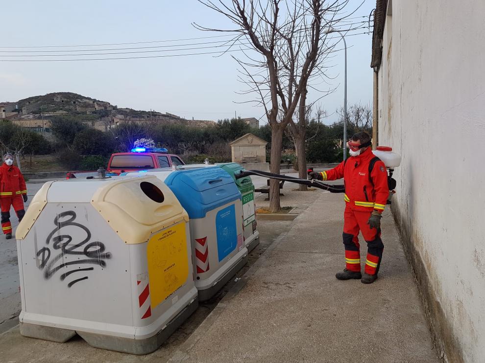 Bomberos voluntarios limpiando los contenedores de Almudévar.