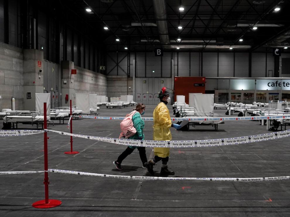 Personal sanitario llega a uno de los pabellones del recinto ferial Ifema, que se preparan para albergar 1.396 camas para atender a pacientes de coronavirus.