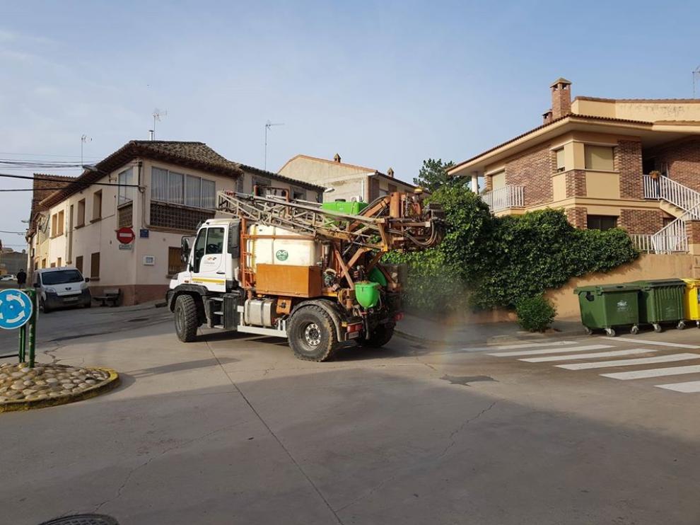Un agricultor utiliza su maquinaria para desinfectar las calles en un municipio aragonés.