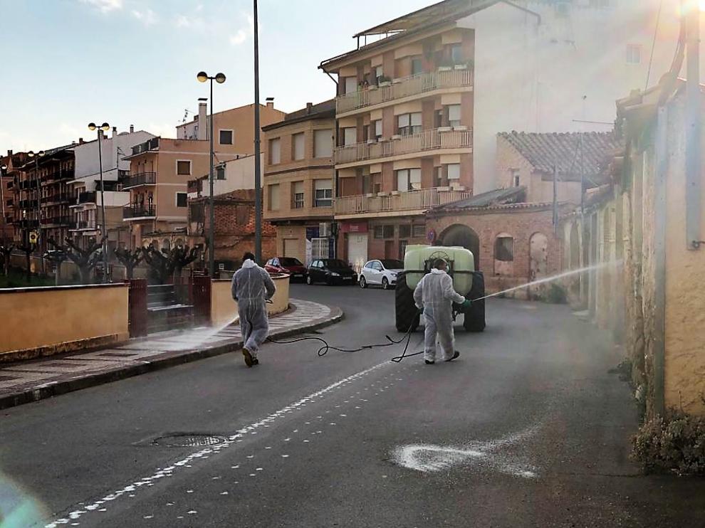Dos operarios fumigan las calles de Alcorisa con un producto desinfectante.