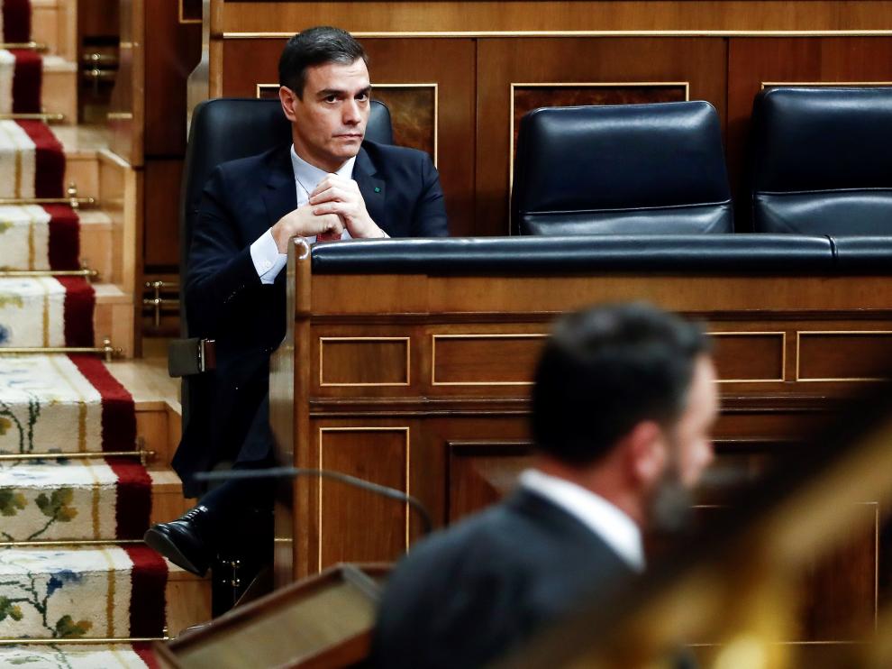 Pedro Sánchez escuchando una intervención de Santiago Abascal