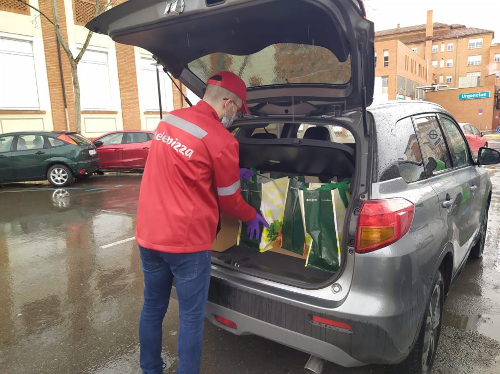 Operarios de Telepizza llevan la comida al albergue municipal.