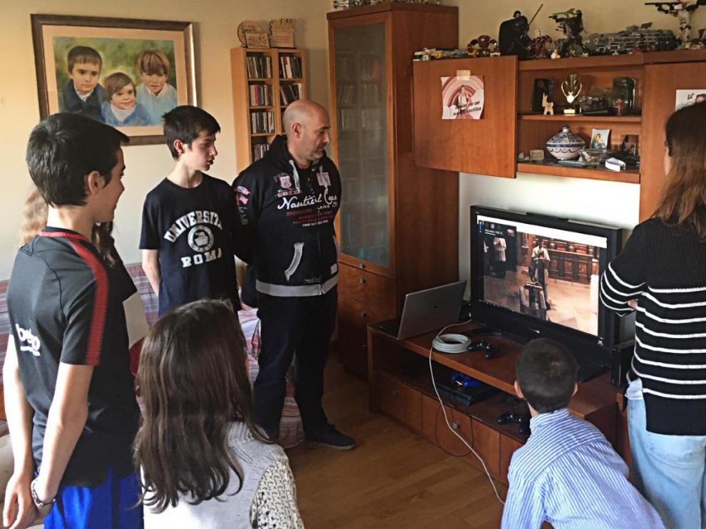 Una familia escucha la misa emitida desde Torreciudad.