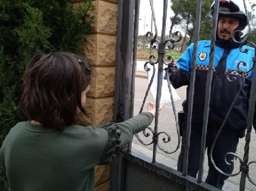 Vicente Sierra, Policía Local de Escatrón, entregando una bolsa de deberes.
