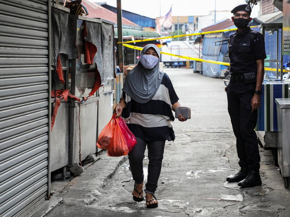 A police officer stands guard at an entrance of a market, during the movement control order due to the outbreak of the coronavirus disease (COVID-19), in Kuala Lumpur