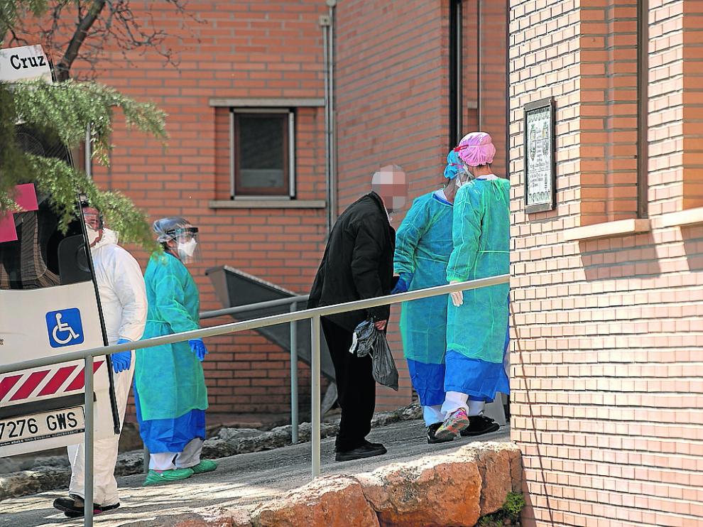 Un anciano, protegido con mascarilla, llega al centro sociosanitario de Alfambra.