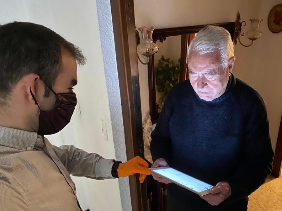 El concejal Carlos Arana muestra a un mayor como funcionan las videoconferencias.