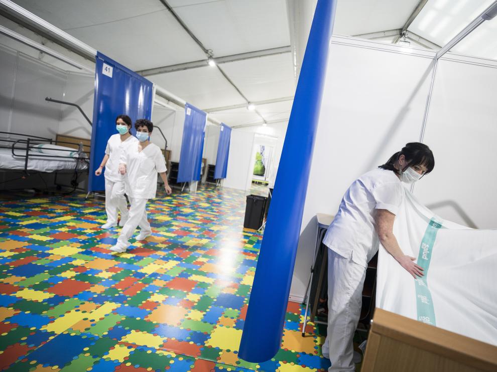 Una trabajadora prepara una de las 35 primeras camas del hospital de campaña de la Multiusos