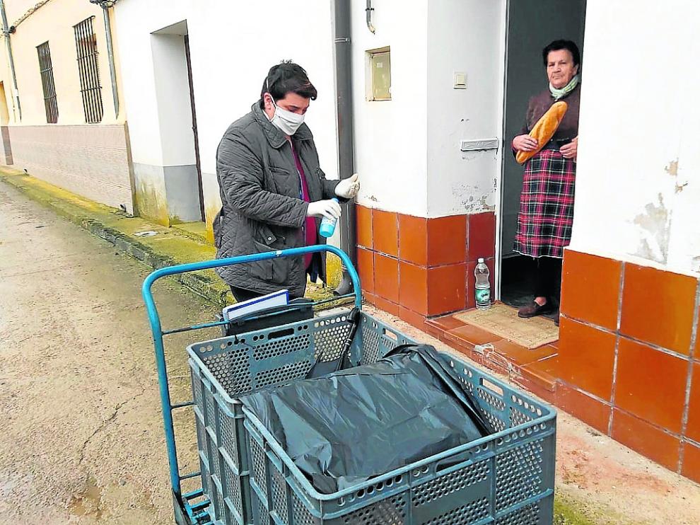 Sonia Lara, gestora del multiservicio de Cuevas Labradas, lleva el pan a una vecina.