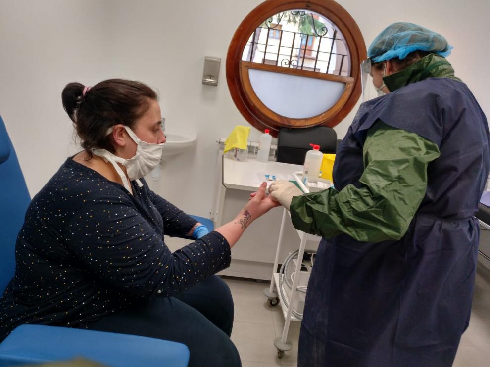 Una enfermera realiza un test rápido de coronavirus a una vecina en Utrillas