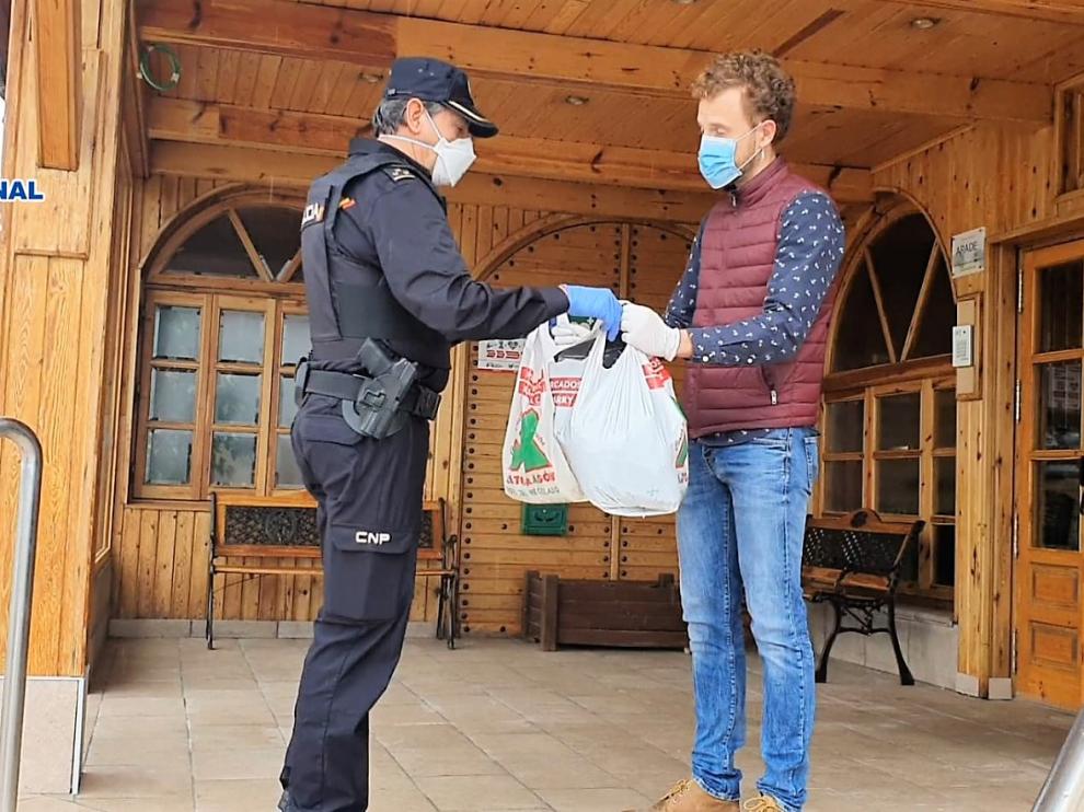 Un agente de la Policía Nacional entrega material al director de la residencia La Abubilla, en Yéqueda
