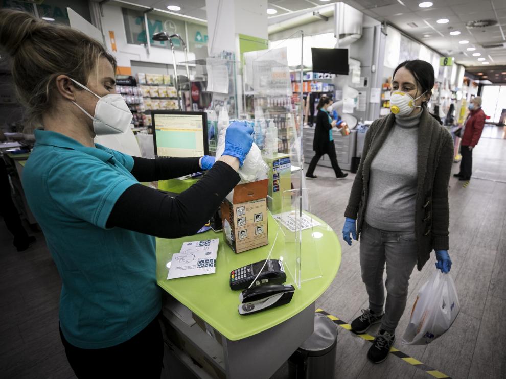 Una clienta compra una mascarilla, ayer en la farmacia Artal Centro de Zaragoza