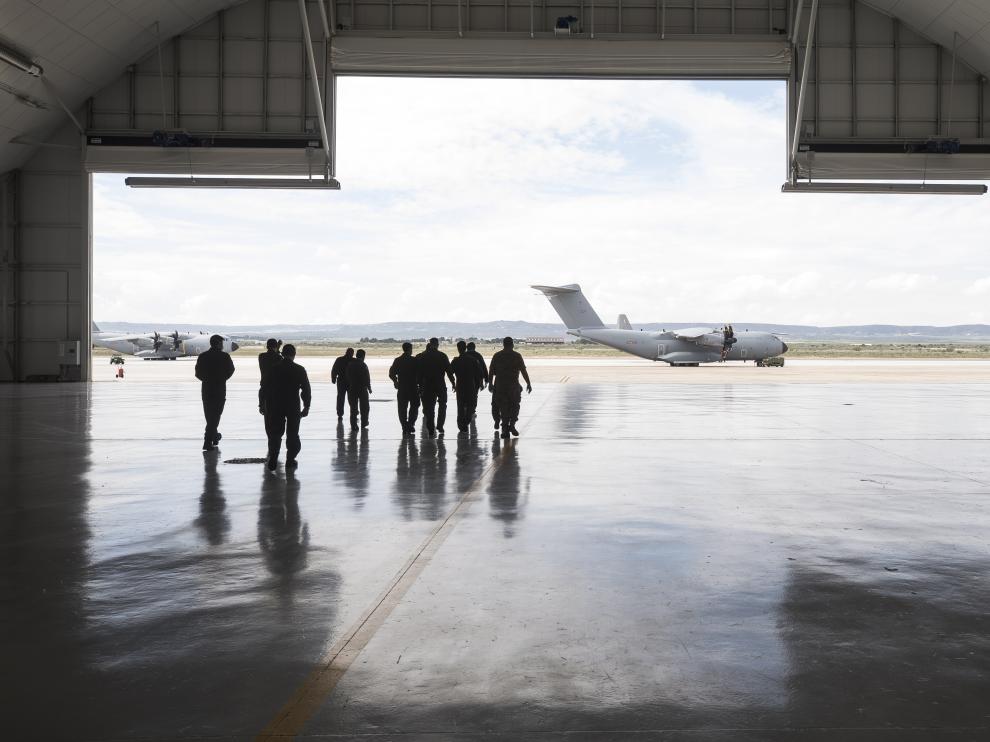 Los pilotos de aviones del Ala 31, protegidos con mascarillas y guantes, salen del hangar hacia la plataforma de la Base Aérea de Zaragoza.