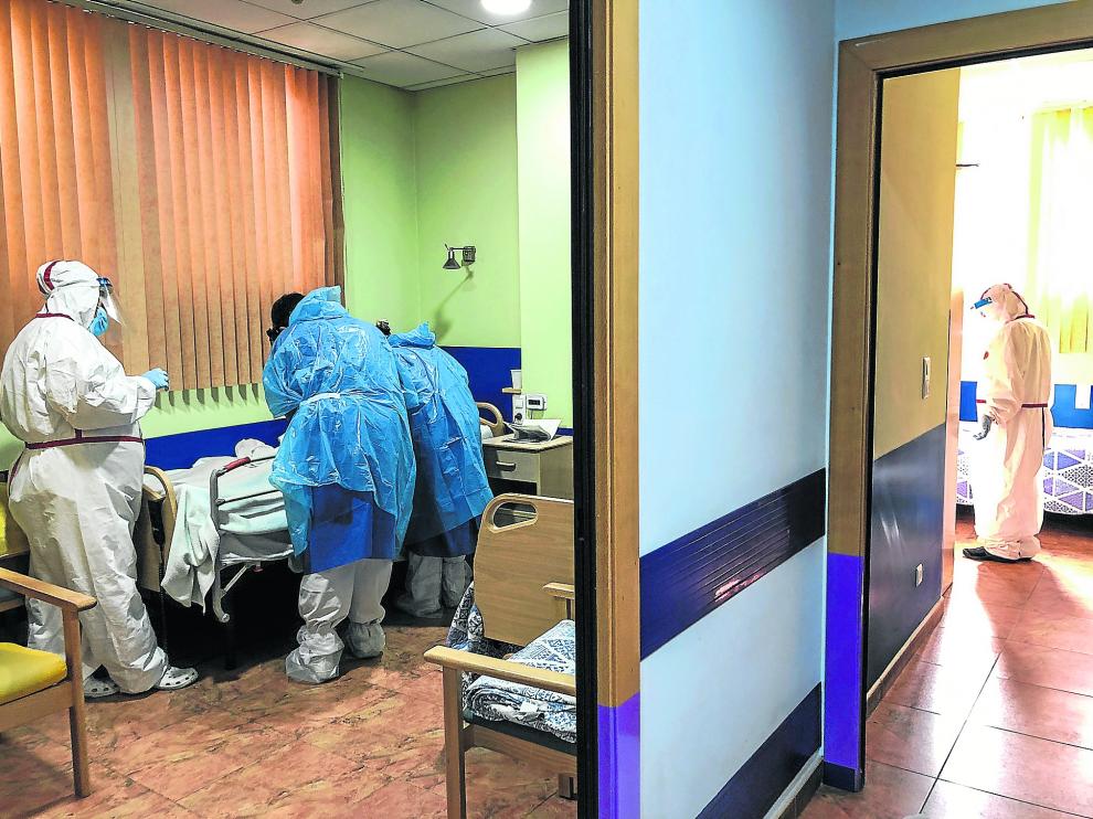 El equipo de EDORE atiende a un paciente con coronavirus acompañado por las gerocultoras de la residencia