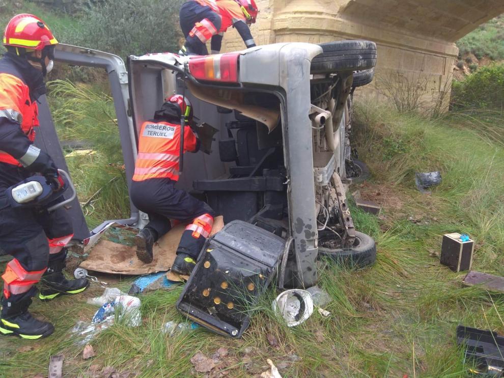 Los bomberos, durante el rescate del conductor herido en Ariño.