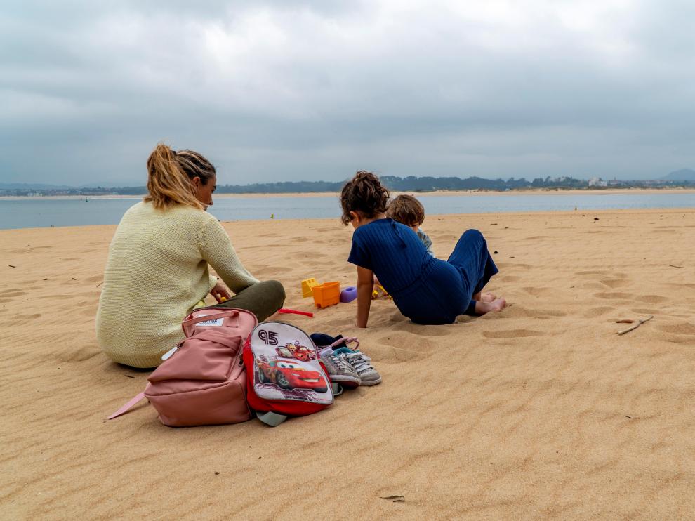 Una mujer con sus dos hijos en la Playa de los Peligros de Santander