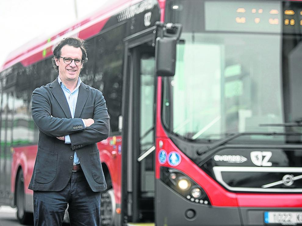 El director de Avanza Zaragoza, Guillermo Ríos, junto a un autobús urbano.