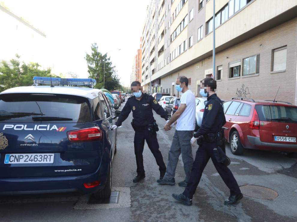 Agentes de la Policía Nacional introducen al guardia civil detenido en el coche patrulla tras registrar su domicilio.