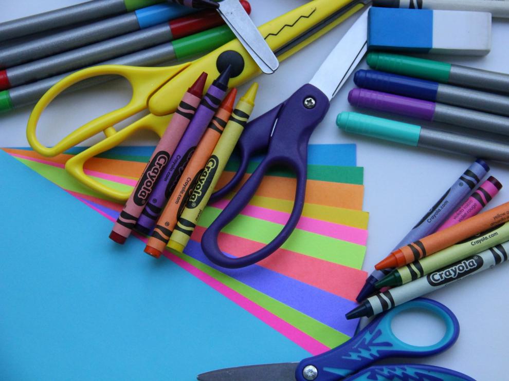 Tijeras, papel y lápices de colores para hacer la manualidad.