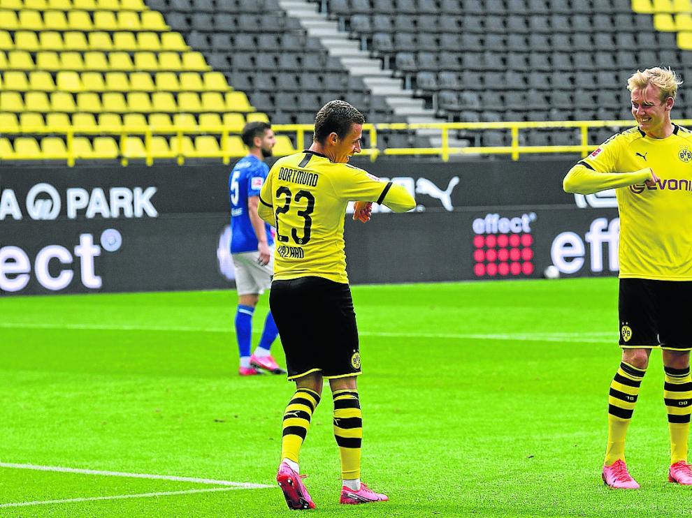Dortmund (Germany), 16/05/2020.- Dortmund's Thorgan Hazard (L) celebrates with Julian Brandt after scoring the 3-0 lead during the German Bundesliga soccer match between Borussia Dortmund and Schalke 04 in Dortmund, Germany, 16 May 2020. The German Bundesliga and Second Bundesliga are the first professional leagues to resume the season after the nationwide lockdown due to the ongoing Coronavirus (COVID-19) pandemic. All matches until the end of the season will be played behind closed doors. (Alemania, Rusia) EFE/EPA/MARTIN MEISSNER / POOL DFL regulations prohibit any use of photographs as image sequences and/or quasi-video. Borussia Dortmund vs Schalke 04