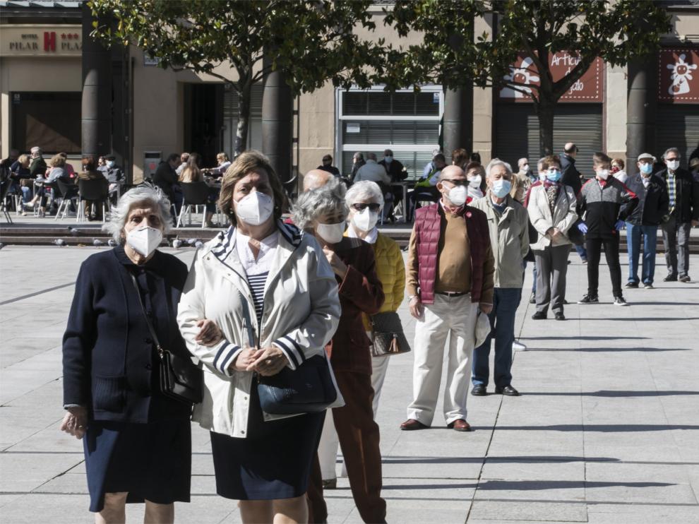 Gente con mascarilla haciendo fila para entrar en la basílica del Pilar de Zaragoza