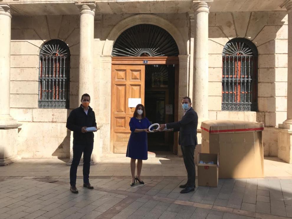 La alcaldesa, Emma Buj, y el primer teniente de alcalde, Ramón Fuertes, entregan el material al presidente de la CEOE, Ángel Muela.